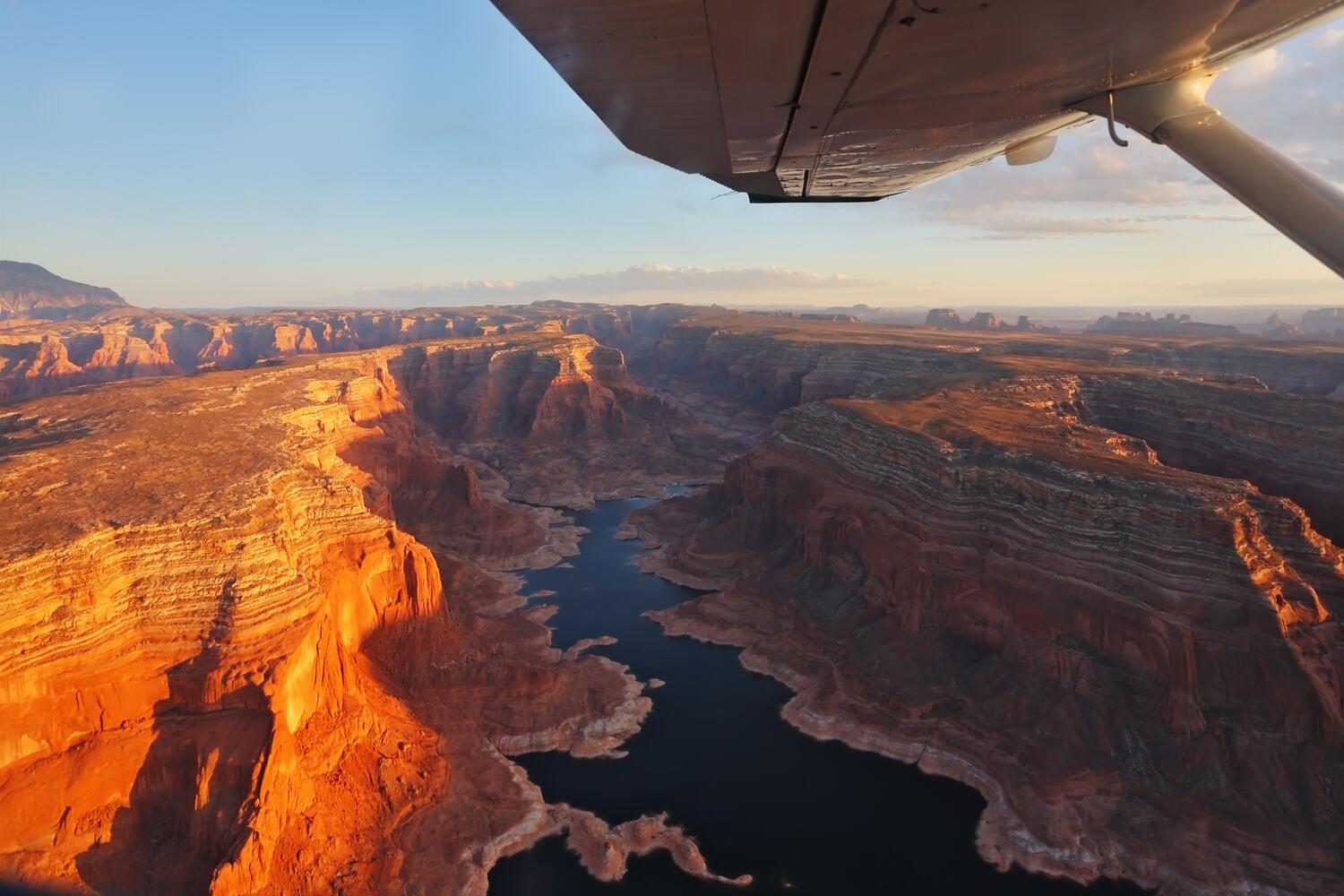 View of a canyon from under an airplane wing