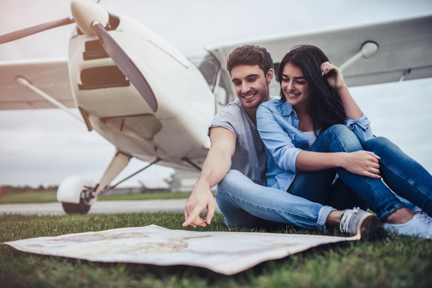 Two people planning a flight under an airplane wing