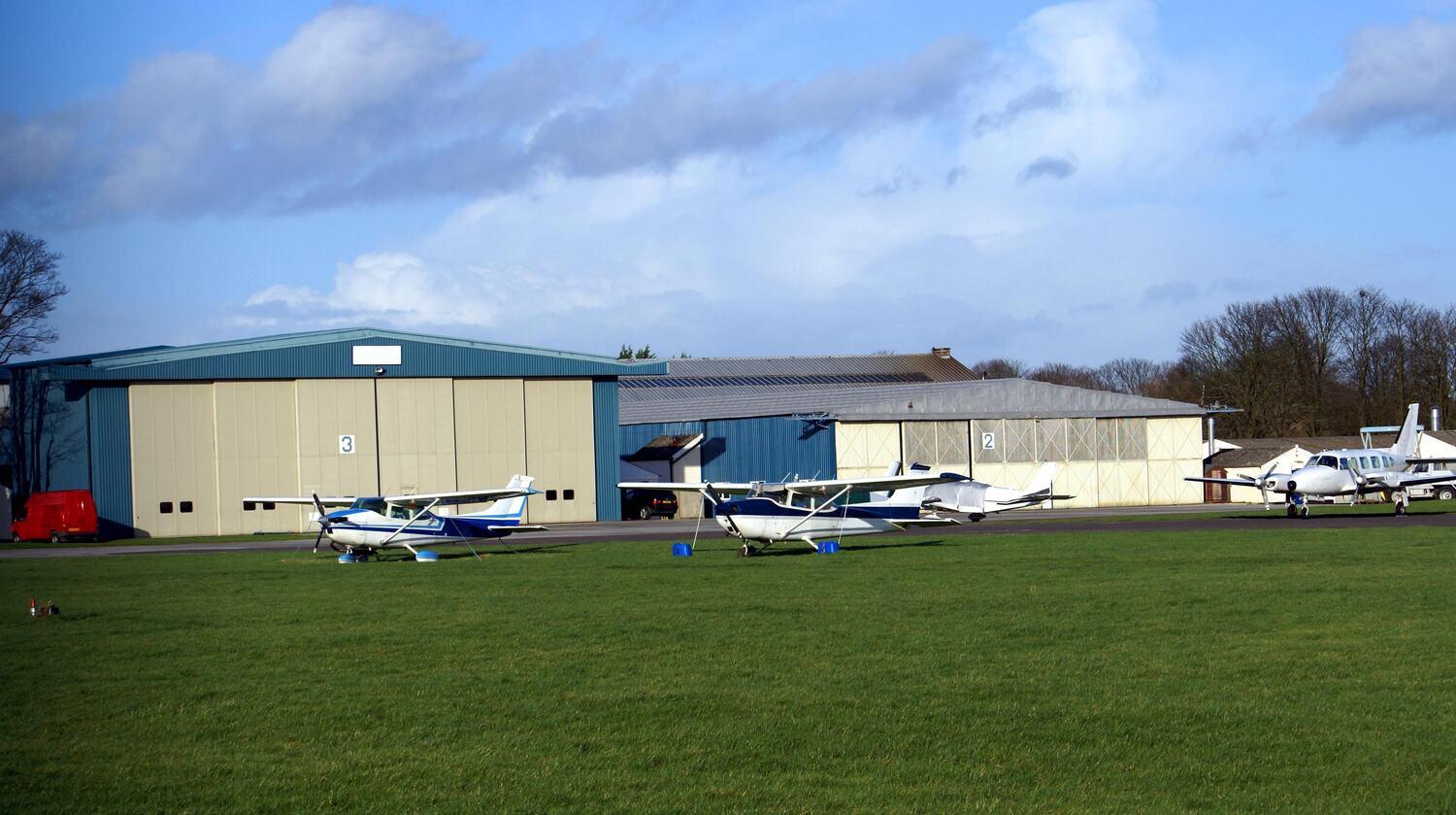 Row of hangars at a grass airfield