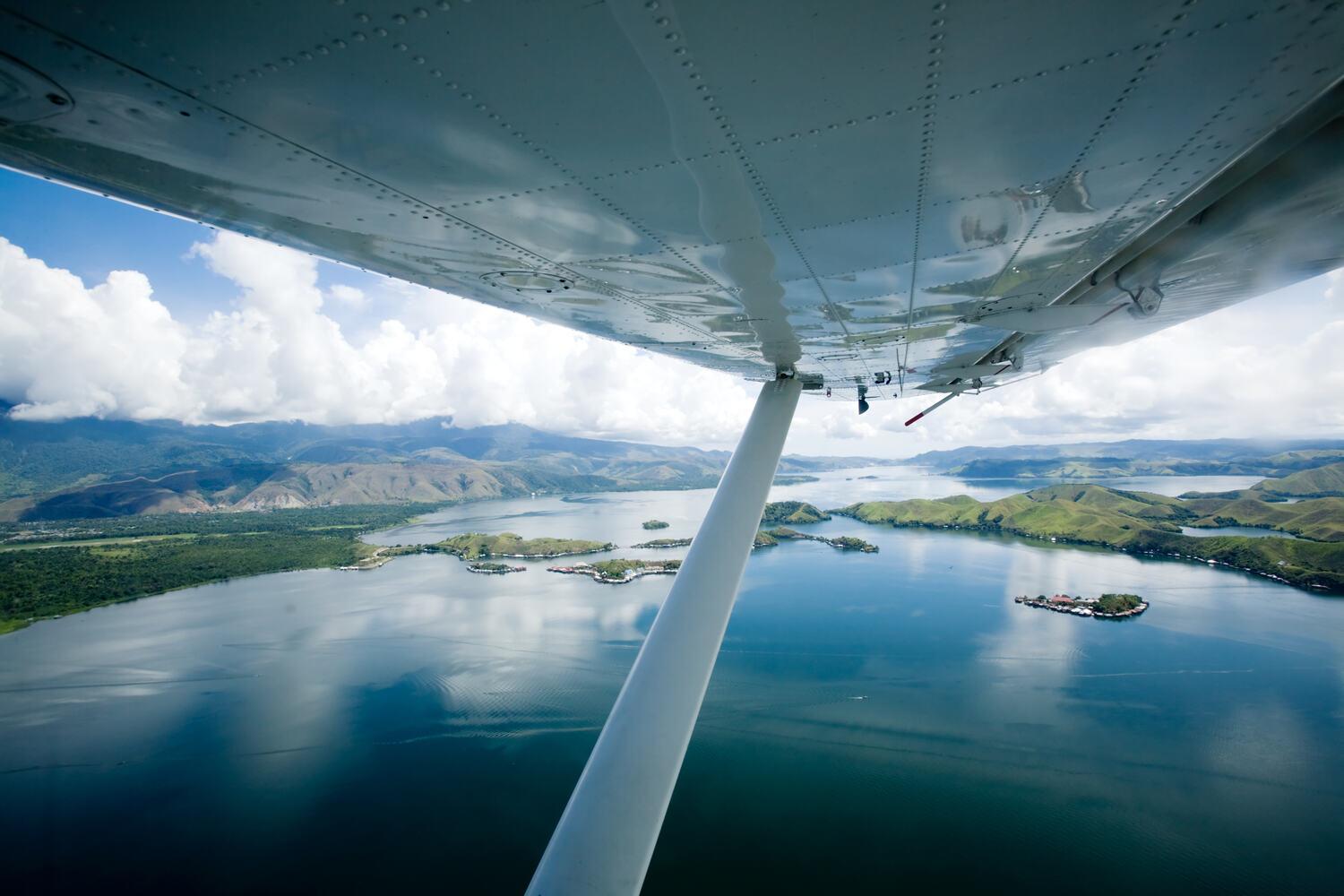 High-wing airplane flying over water