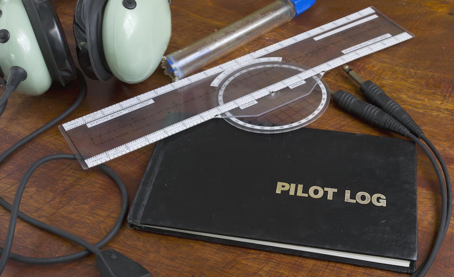 Pilot logbook and navigation plotter on a desk